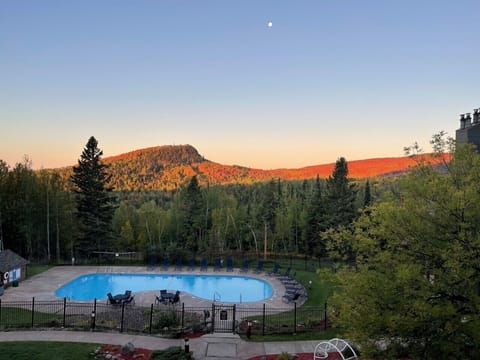 Terrace View: Unwind by the pool with breathtaking mountain vistas at sunset!