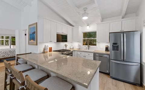 A wide kitchen island here offers plenty of room for guests to pull up a chair and keep the conversation going while the chef prepares a meal