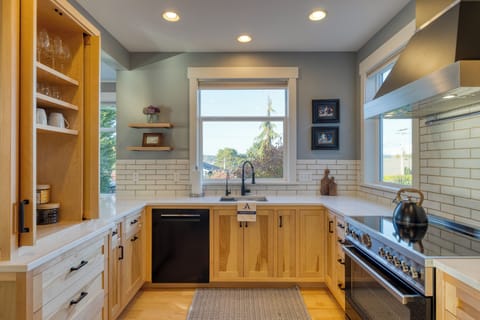 Modern kitchen with white cabinets and stainless steel appliances.