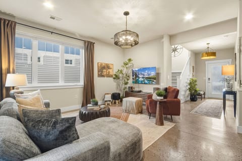 Sink into plush sofas in your stylish living room, where a stunning chandelier illuminates your relaxation space perfectly.