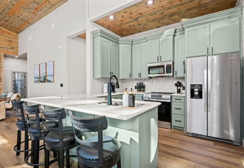 The large island doubles as a breakfast bar, perfect for morning coffee or casual afternoon snacks.