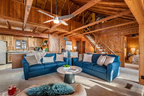 Settle in for a cozy night by the fireplace, surrounded by vaulted ceilings and rich wood beams that bring comfort, warmth, and a true Up North feel.