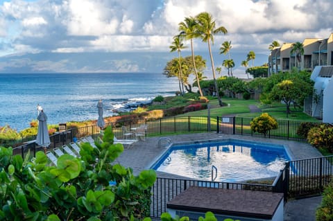 Peaceful ocean-view pool at Napili Point with loungers and umbrellas, set above the rocky shoreline for quiet swims and postcard-worthy sunset views.