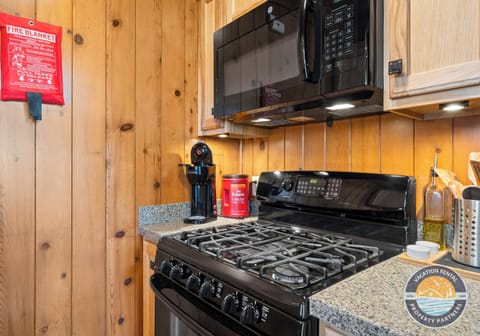 Open-concept comfort: A well-equipped kitchen flows seamlessly into the main living space, with stairs leading to the loft above. Designed for shared meals, easy mornings, and relaxed evenings under one roof.