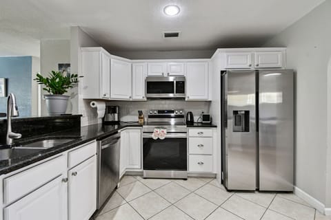 The kitchen is fully equipped with stainless steel appliances, including a refrigerator, oven, and dishwasher, making cooking and meal prep a breeze! 