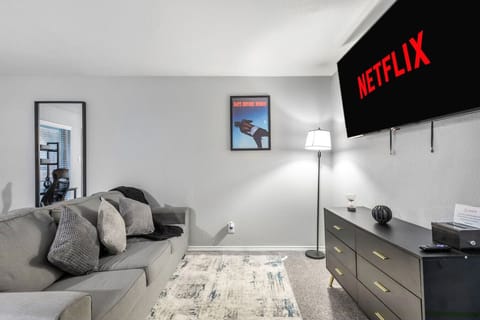 Spacious and inviting living area with comfortable seating and a smart TV, perfect for relaxing after exploring Arlington or attending events at AT&T Stadium.