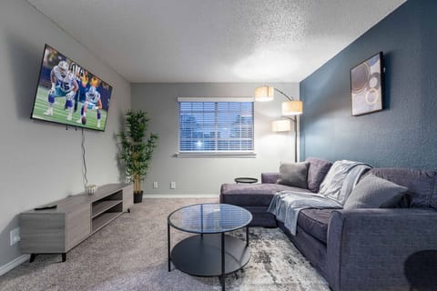 Spacious and inviting living area with comfortable seating and a smart TV, perfect for relaxing after exploring Arlington or attending events at AT&T Stadium.