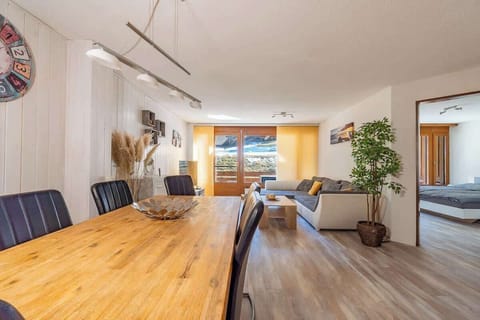 Bright open-plan living and dining area with balcony access