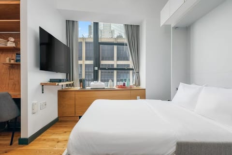 Wake up refreshed in crisp linens beside sunny skyline views.