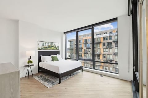 Unwind in a sunlit bedroom with expansive city views.