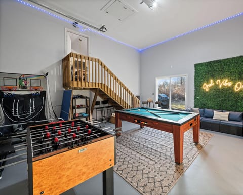Ultimate game room with foosball, convertible pool/air hockey table, basketball arcade, and lounge seating - endless family fun!