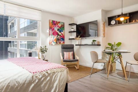 Charming studio with vibrant decor and cozy seating, perfect for a relaxing stay in the heart of the city.
