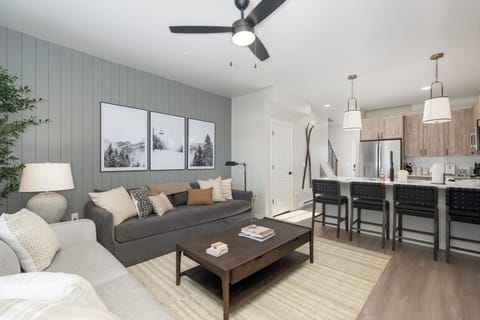 Sink into your stylish open-concept retreat, where modern mountain charm meets comfort with plush seating and a sleek kitchen perfect for cozy evenings.