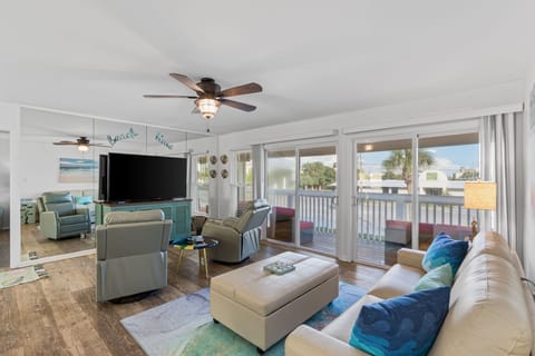 Your spacious living room welcomes you with coastal charm, comfortable seating, and ocean breezes flowing through expansive sliding doors to your private balcony.