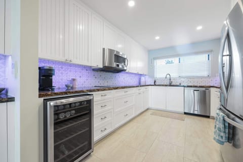 Full-sized refrigerator, built-in microwave, stovetop, and a dedicated wine cooler are ready for your culinary adventures. Enjoy the modern, well-lit backsplash!