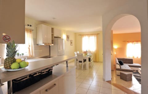 The kitchen and dining area of one apartment are bright and airy, opening up through an archway into the separate, adjacent living room.