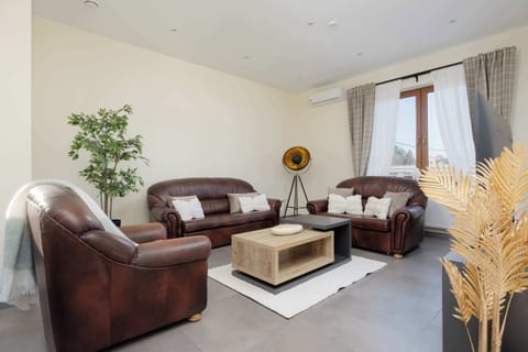 1️⃣ Cozy living area with soft natural light and comfortable leather sofas, perfect for relaxing after a day of exploring the city.