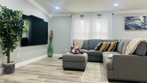 Spacious living room with a comfortable sectional sofa and large wall-mounted TV