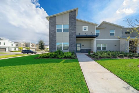 Modern townhouse with stone accents and a spacious front lawn