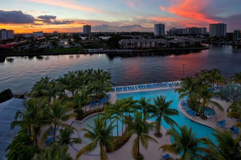Property pool by palms and colorful sunset skies.