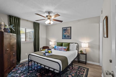 primary bedroom with queen bed, smart TV, and private bathroom 