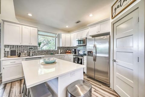 White cabinetry, stainless steel appliances, and Hill Country views from the sink.