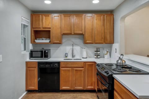 MAIN HOUSE: Fully equipped kitchen with warm wood cabinetry, tiled backsplash, and modern appliances for all your cooking needs