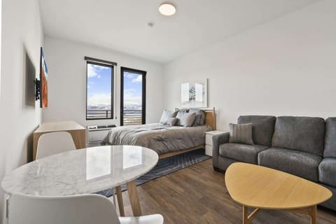 Larger view of living space with dining table, sofabed, and coffee table