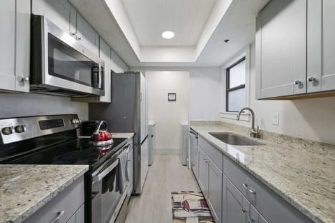 Modern kitchen with stainless steel appliances, granite countertops, and ample cabinet space — fully equipped for your stay.