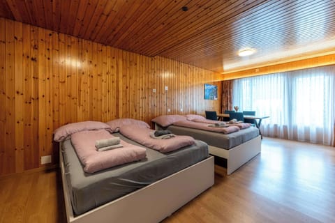 Cozy sleeping area with multiple beds and natural light