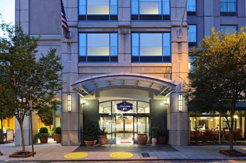 Main entrance with glass doors, trees, and covered walkway