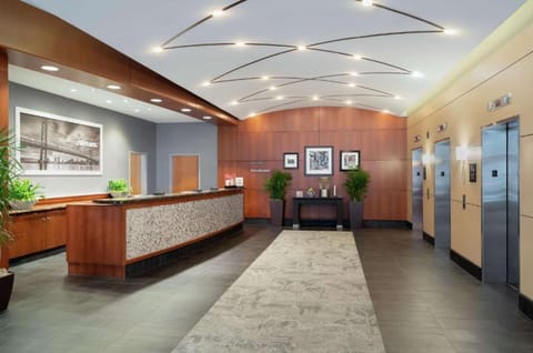 Lobby with front desk, elevators, and bright ceiling lights