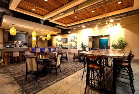 Bar and dining area with wooden tables and warm hanging lights