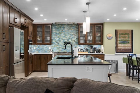 Beautiful gourmet kitchen featuring stainless appliances, large island with seating, and fully equipped cookware for longer stays and family gatherings.