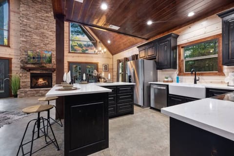 Tall ceilings and natural light define the transition from dining to relaxation. Grab a stool at the breakfast bar for your morning coffee before heading to the cozy gas fireplace in the living room. This seamless layout ensures that even while you’re coo