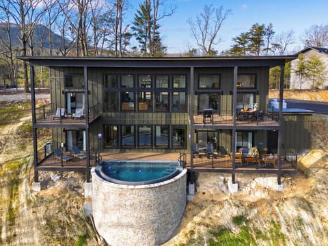 Striking modern mountain retreat featuring panoramic glass walls and an infinity-edge plunge overlooking the valley.
