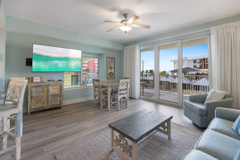 Relax in your coastal-themed living space with soft sage walls, comfy seating, and a private balcony perfect for morning coffee.
