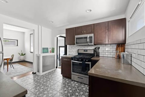 Fully equipped kitchen with stainless steel appliances, subway tile backsplash, and ample cabinet