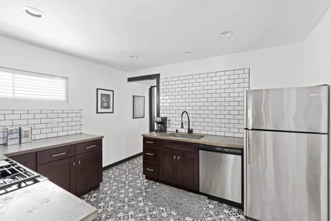 Fully equipped kitchen with stainless steel appliances, subway tile backsplash, and ample cabinet