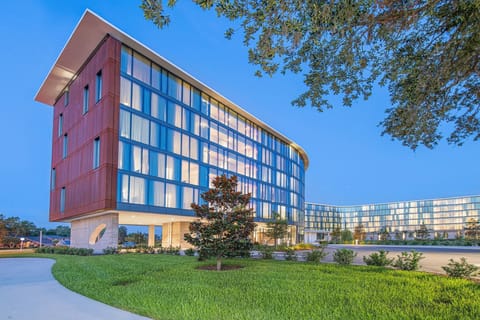 The distinctive facades of Hotel ELEO blend contemporary architecture with organic elements, showcasing a stunning contrast against the twilight sky.