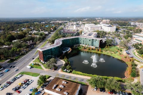Offering a bird’s-eye view, this elegant hotel showcases its sleek design with expansive glass panels that reflect the beauty of its surroundings.
