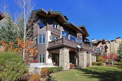 Embrace the vibrant autumn scenery surrounding this exquisite townhome, highlighted by rich stone accents and a spacious outdoor area ideal for enjoying the breathtaking views.