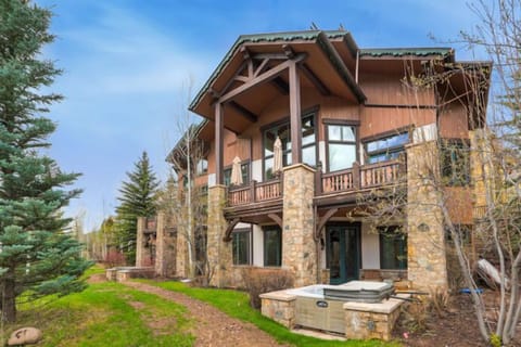 Experience the elegance of mountain living in this stunning stone and wooden townhome, featuring expansive windows that invite stunning views of the surrounding Alpine beauty.