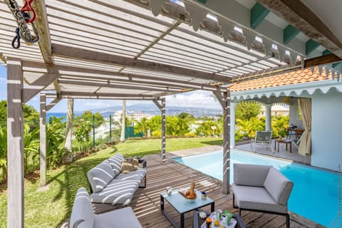 Renting Villa Coralyne in Les Trois-Îlets guarantees a peaceful stay. Enjoy a beautiful wooden deck shaded by a pergola—the perfect spot to relax in the outdoor lounge area overlooking the pool and the ocean view.