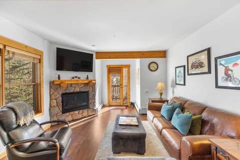 Sink into plush leather seating beside your crackling stone fireplace, where mountain views and cozy warmth create the perfect retreat.