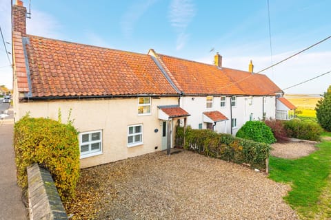 1 Ruscon Cottage, Brancaster Staithe: Front elevation with a glimps of the marsh