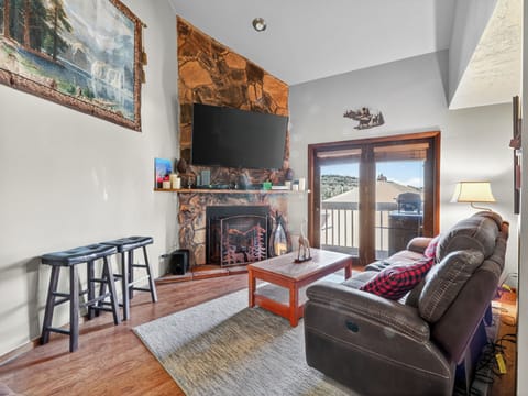 Relax in your cozy mountain retreat with a crackling stone fireplace, comfortable leather seating, and stunning ski slope views from your private balcony.