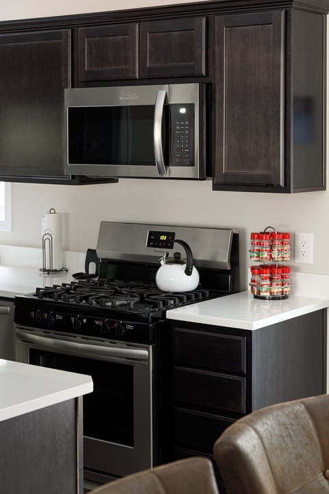 Gas stove w/ sleek finishes, perfect for home-cooked meals & morning coffee.