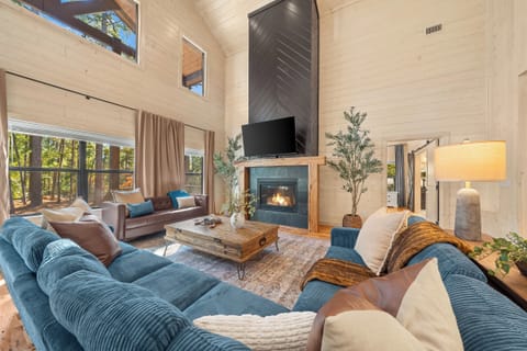 A living room designed for connection. Floor to ceiling windows, a dramatic fireplace, and cozy textures bring everyone together.