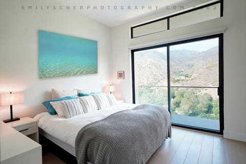 Primary bedroom with balcony and majestic mountain view